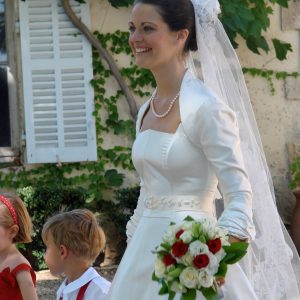 DAUPHINE - Robe de mariée bustier corseté en satin duchesse de soie, ceinture en gros grain brodée de perles et boléro manches 3/4 avec plissage au revers.
