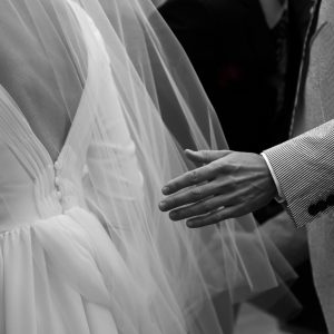 LOUISE - Robe de mariée en crêpe de soie avec l’encolure et le bord du décolleté dos plissés en mousseline de soie et une petite traîne également en mousseline de soie. Voile simple en tulle.